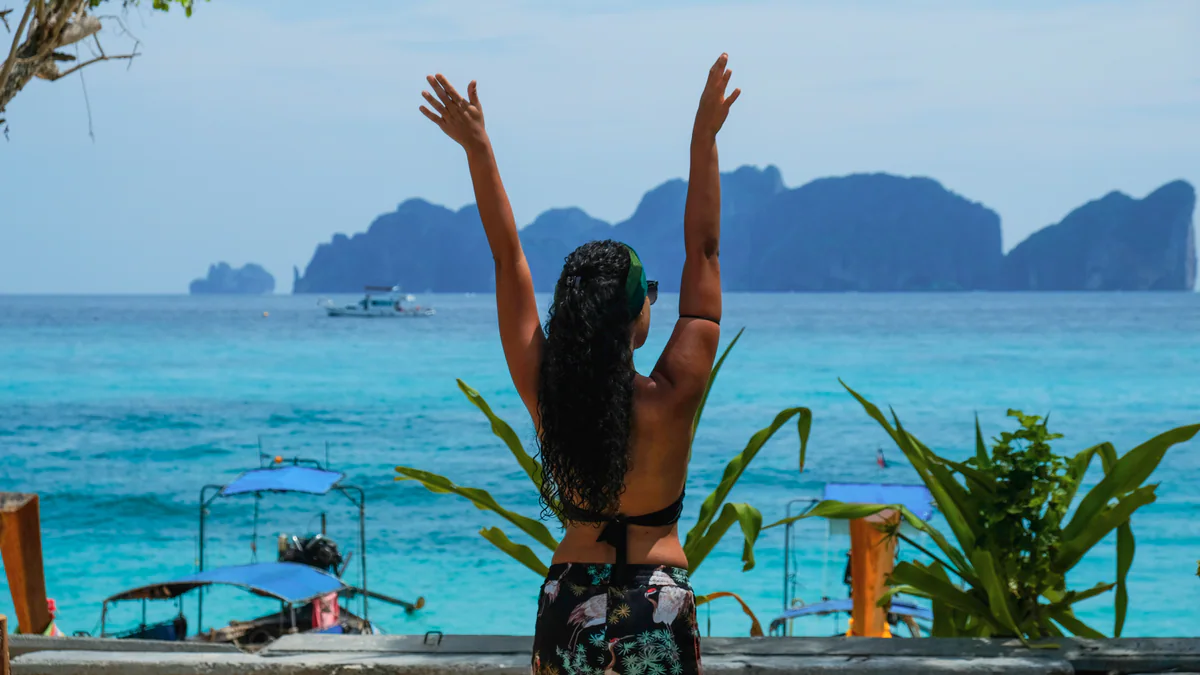 Samira di spalle, con le braccia alzate, davanti alle isole Phi Phi