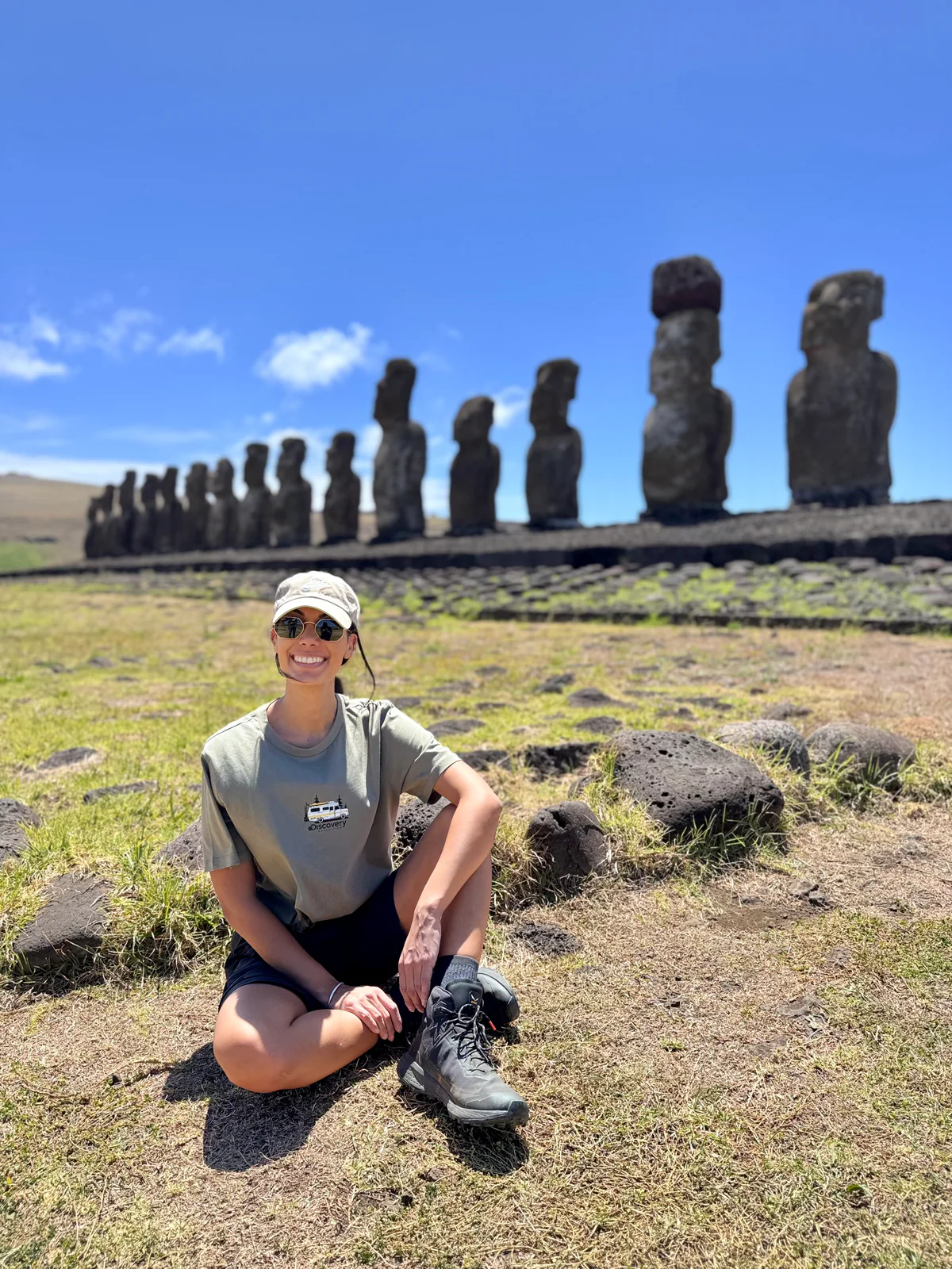 Samira seduta nell'erba davanti alla fila di moai dell'Isola di Pasqua
