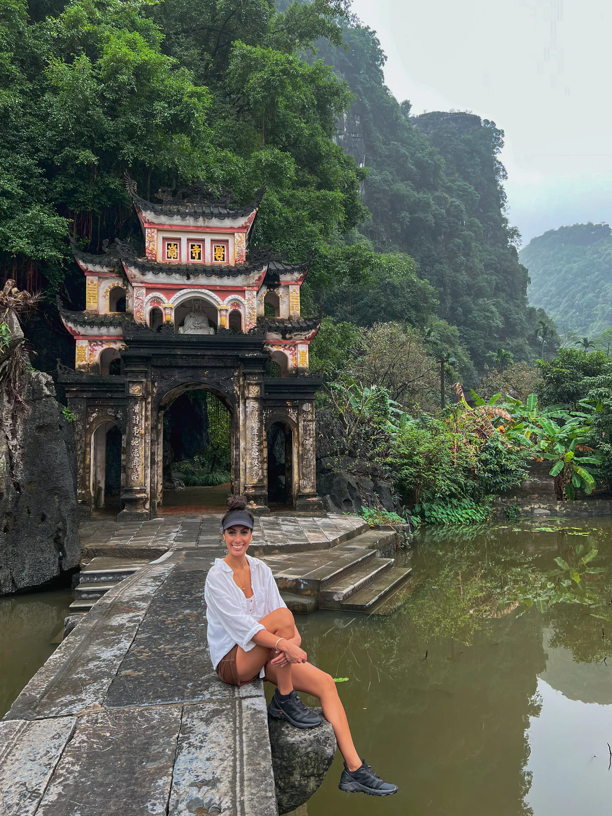 Samira seduta accanto alla porta di una pagoda, tra l'acqua e le montagne carsiche