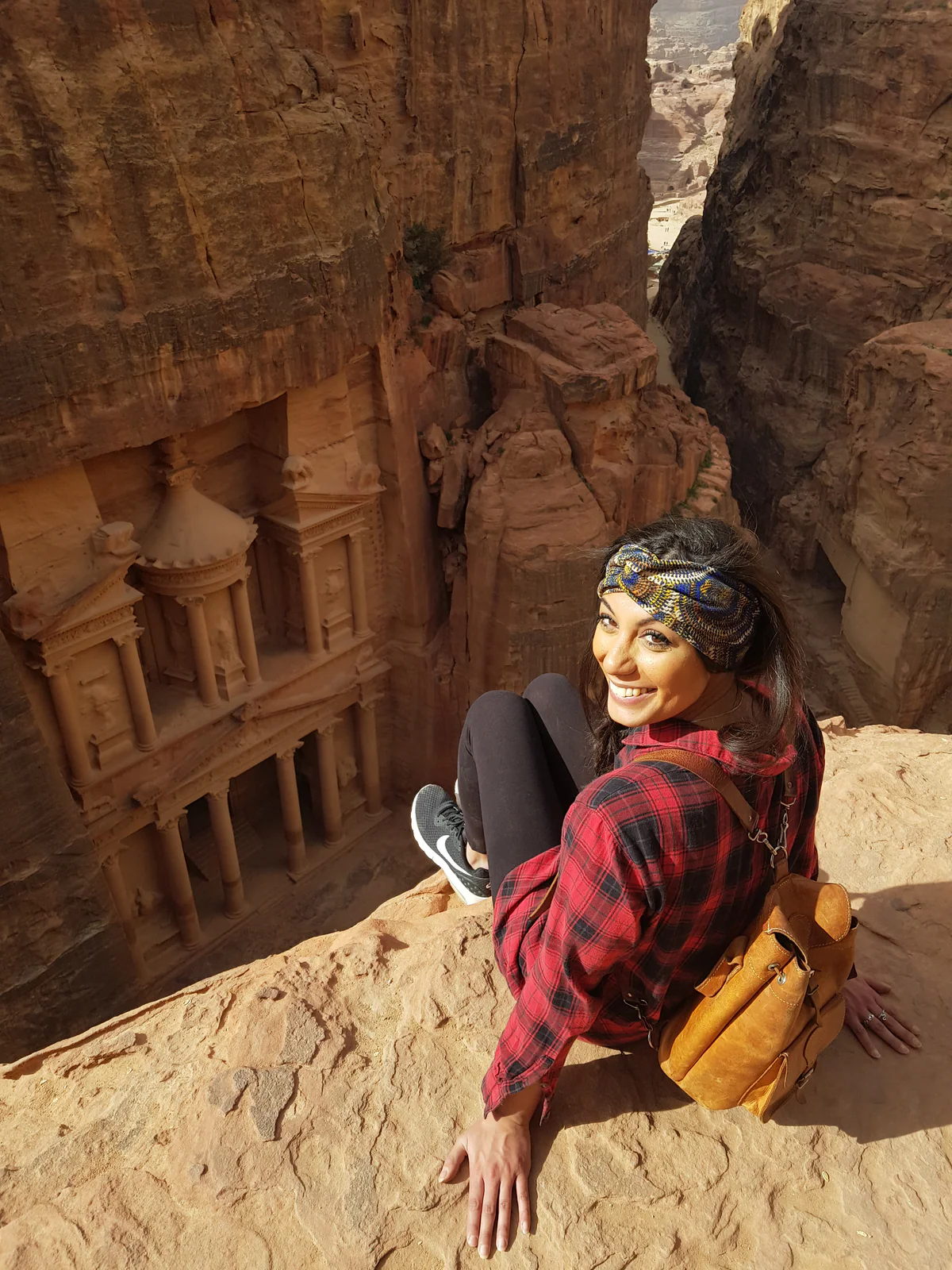 Samira seduta sulle rocce davanti al Tesoro di Petra