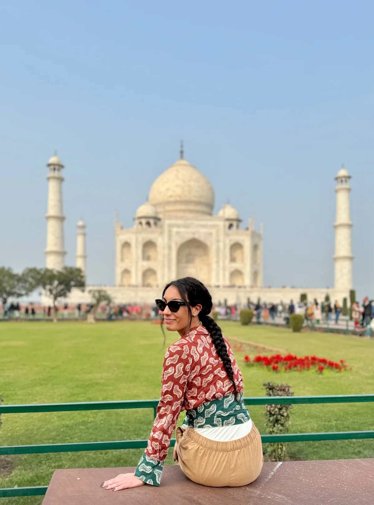 Samira seduta su un muretto davanti al Taj Mahal